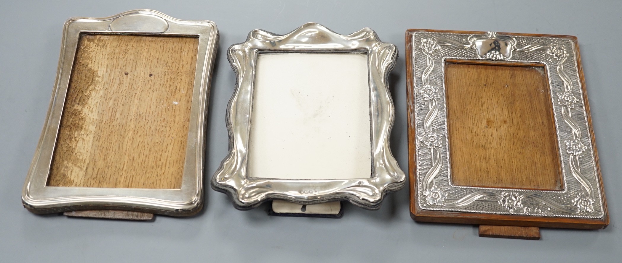 Three assorted early 20th century silver mounted photograph frames, including repousse, Birmingham, 1904, 18.6cm.